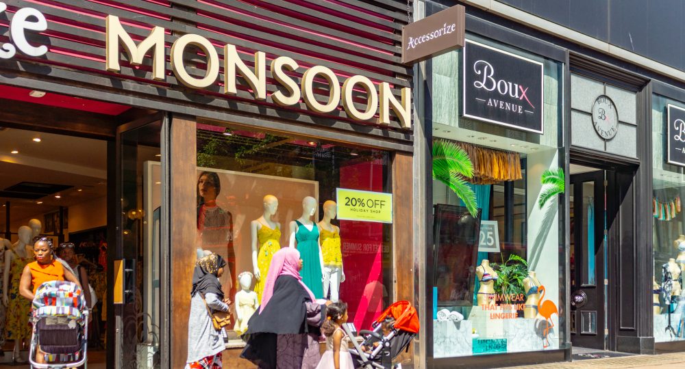 Crowds of shoppers on Regent Street in Central London, UK in the summer of 2018. In the foreground is a Muslim women pushing a stroller.